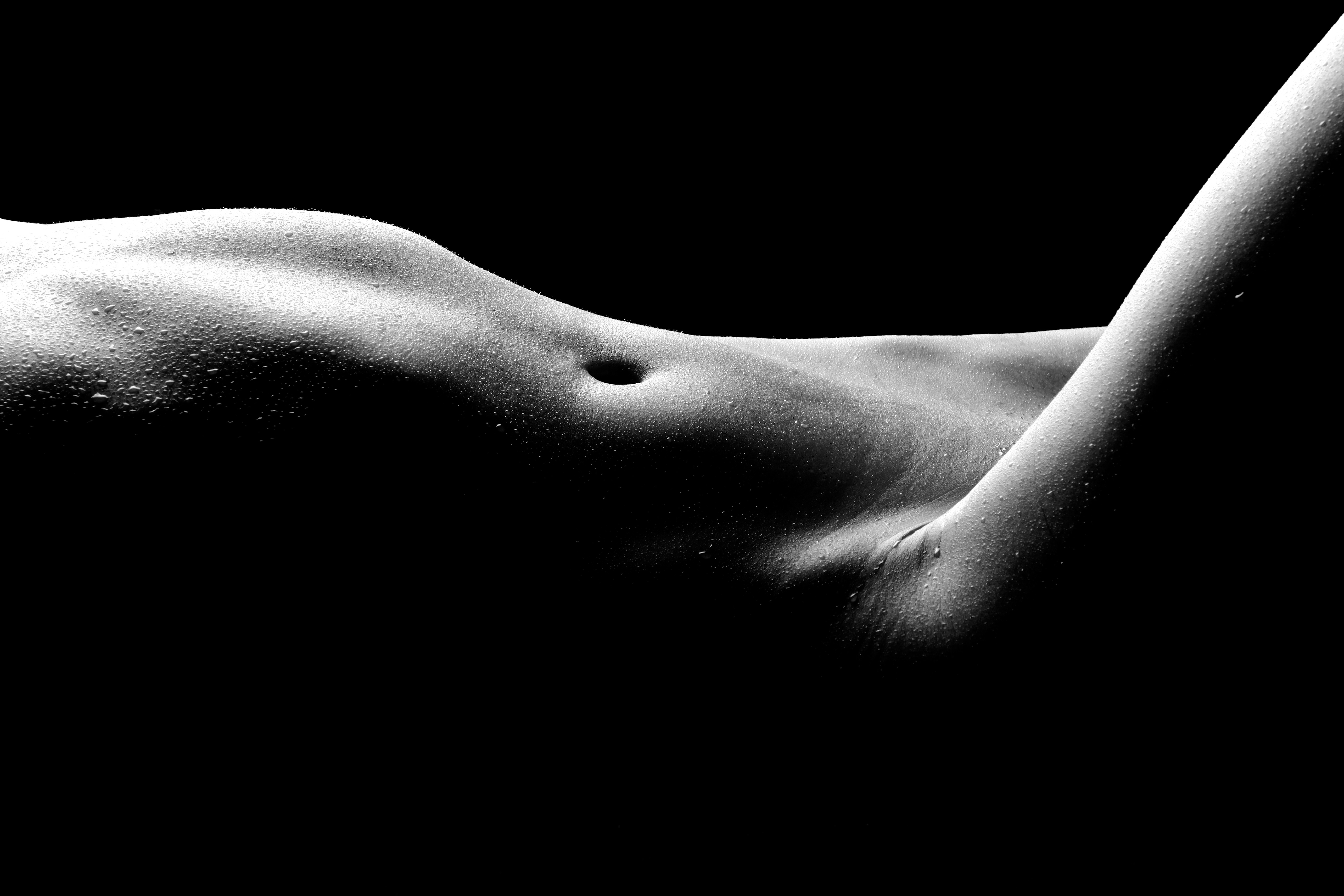 Liposuction photo of a woman laying down in a grey scale photo showing off new curves